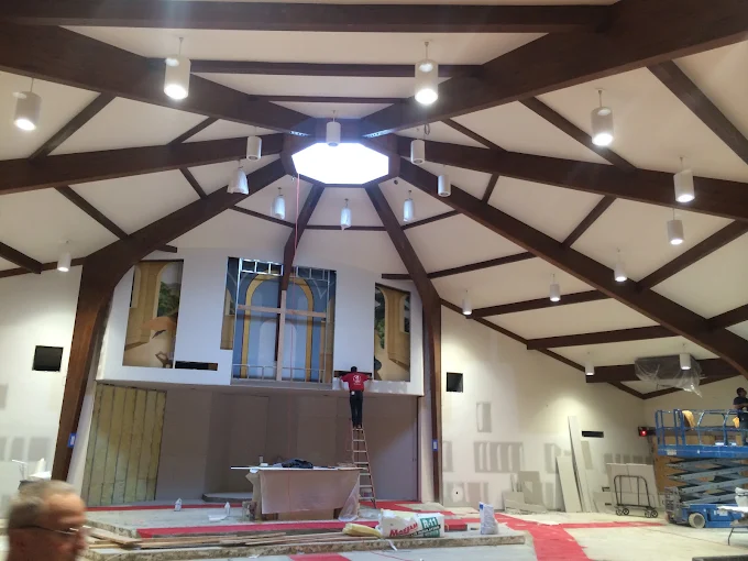 ECCG electricians installing pendant and accent lighting across a large vaulted timber-beam ceiling