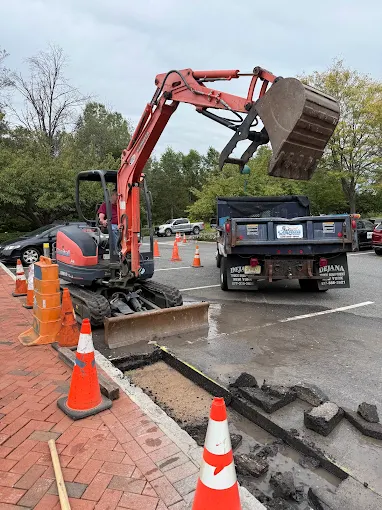 Excavator trenching a parking lot for underground electrical service